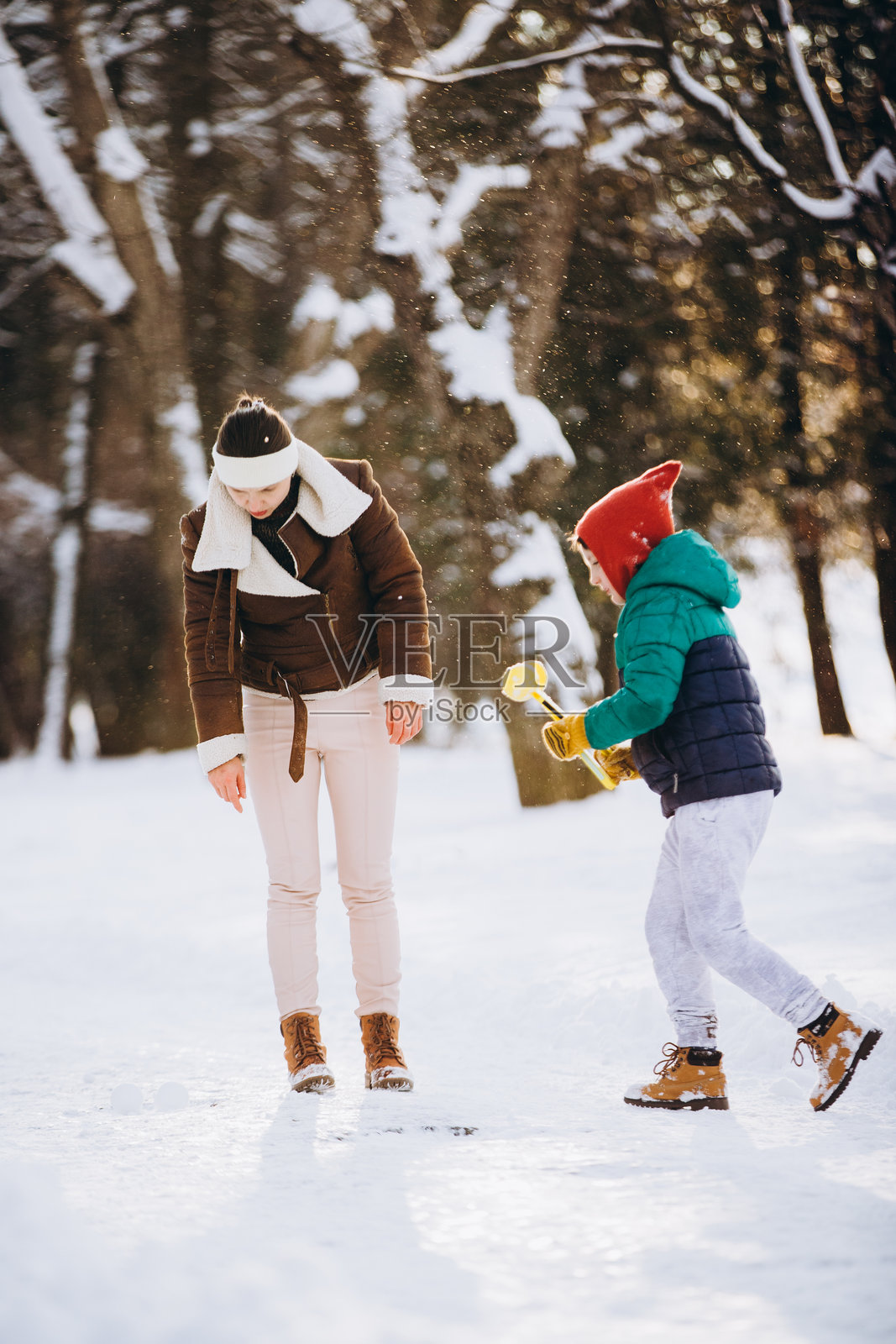冬日公园里,一位母亲和她的儿子在玩雪照片摄影图片