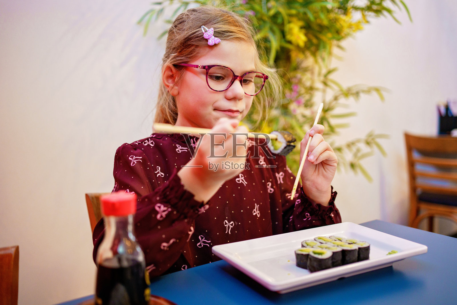 小女孩在餐厅吃寿司,开心健康的食物照片摄影图片
