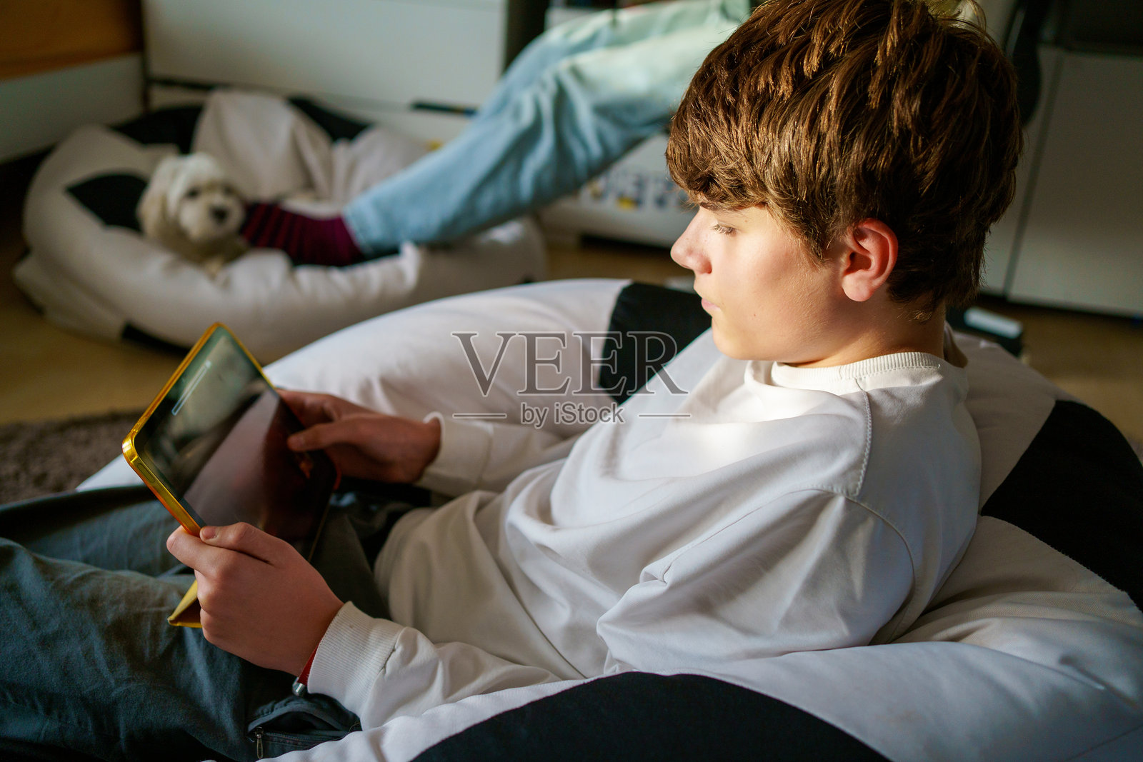 青少年男孩在平板电脑上做学校作业。孩子在家学习。照片摄影图片