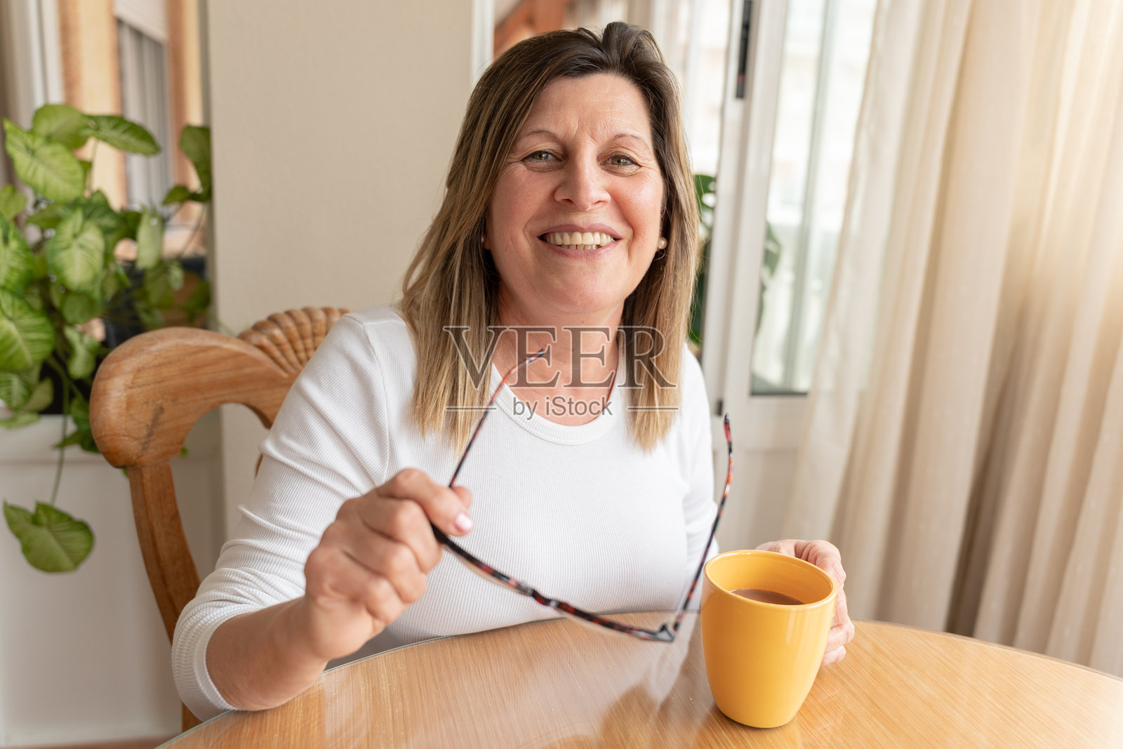 一位成熟的成年女性在家中享受咖啡并微笑照片摄影图片