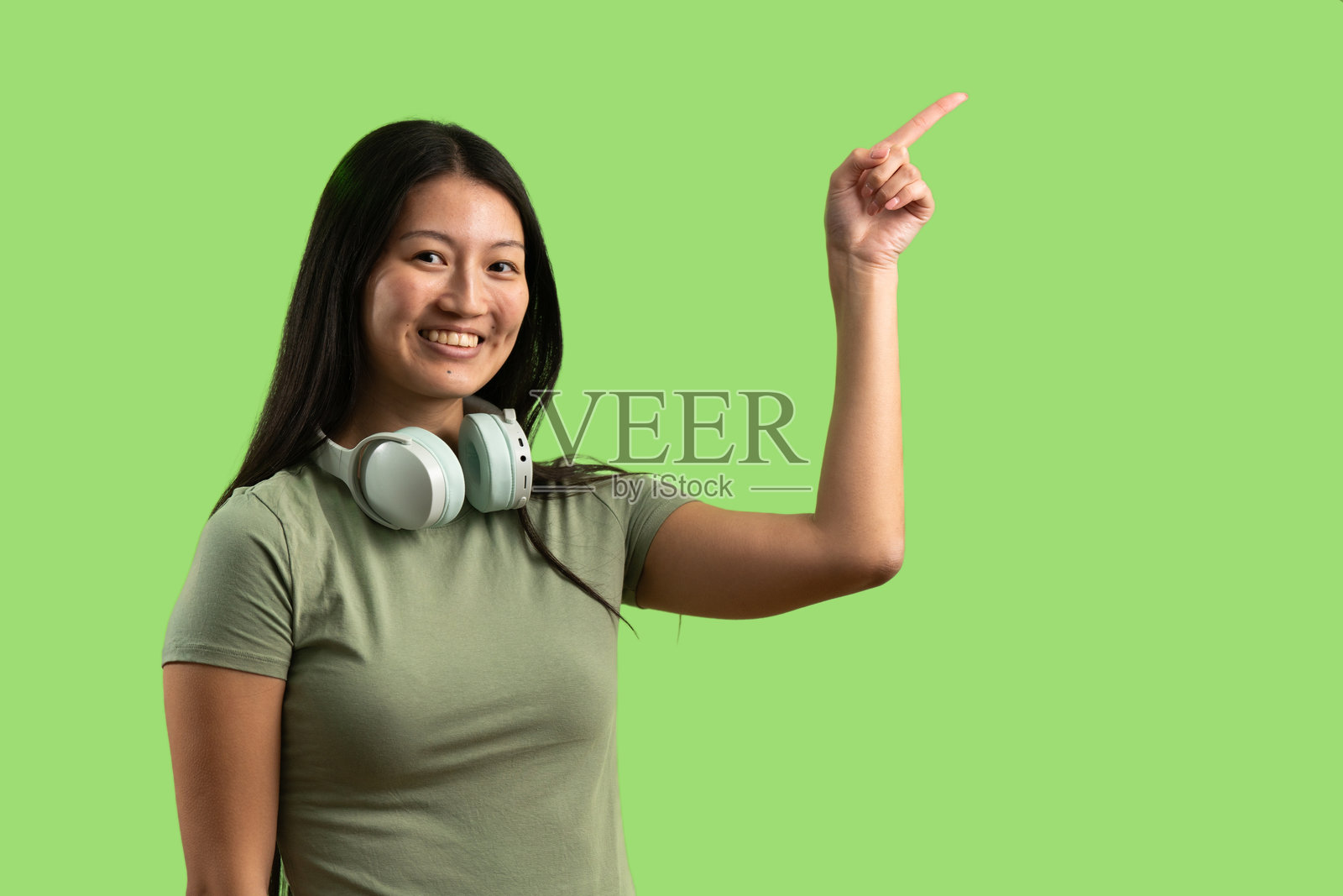 年轻女子指向绿色背景照片摄影图片