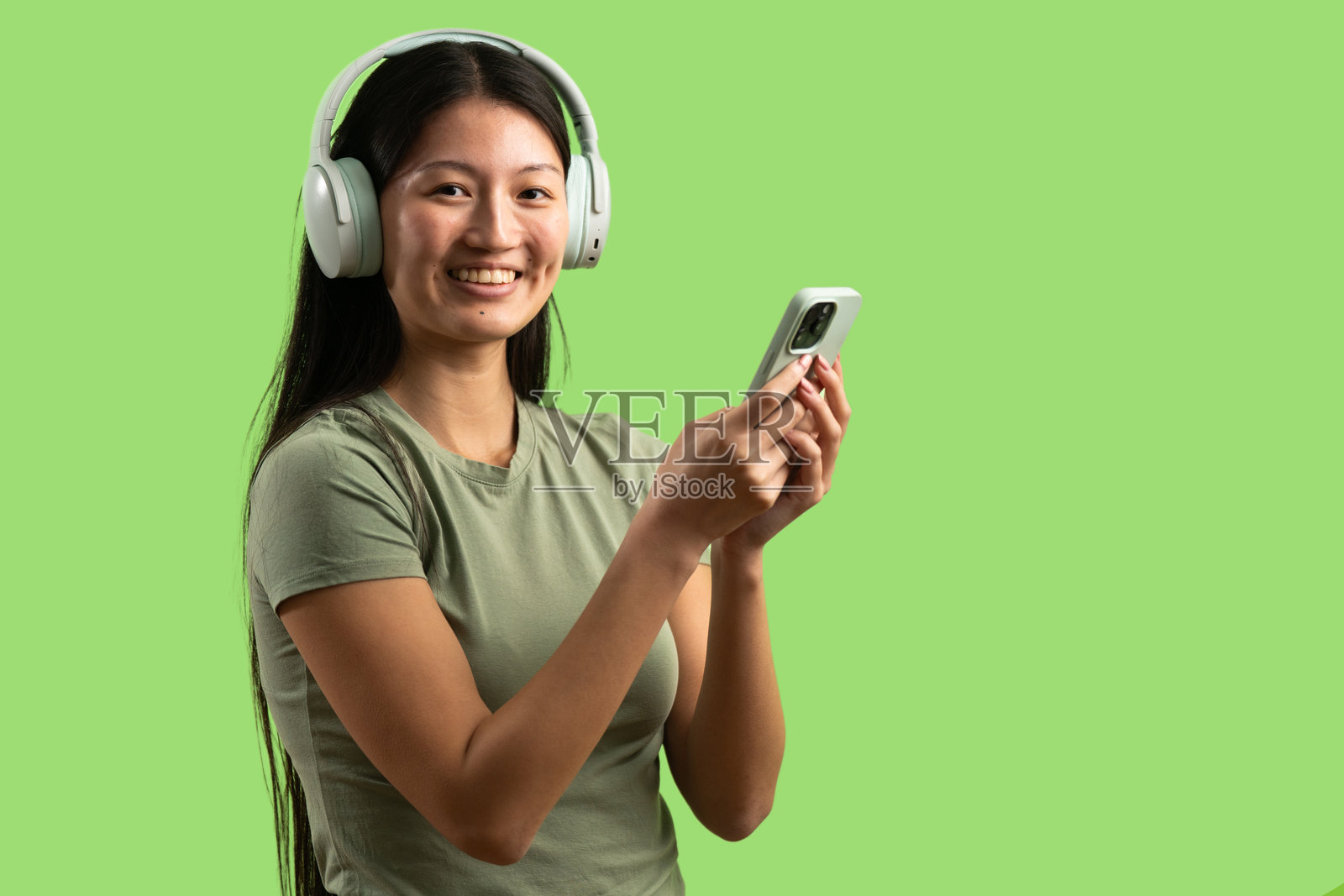 亚洲女性戴着耳机用智能手机听音乐照片摄影图片