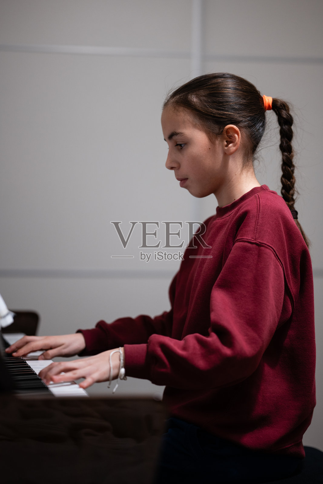 小女孩在练习弹奏钢琴,掌握音乐技巧照片摄影图片