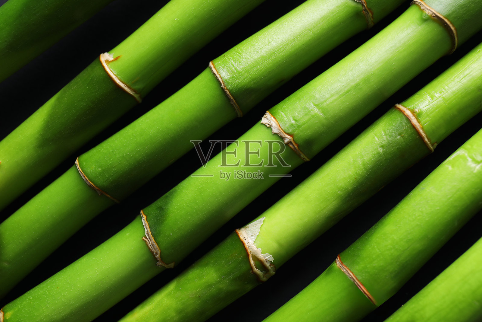 黑色背景上的绿色竹竿,俯视角度照片摄影图片