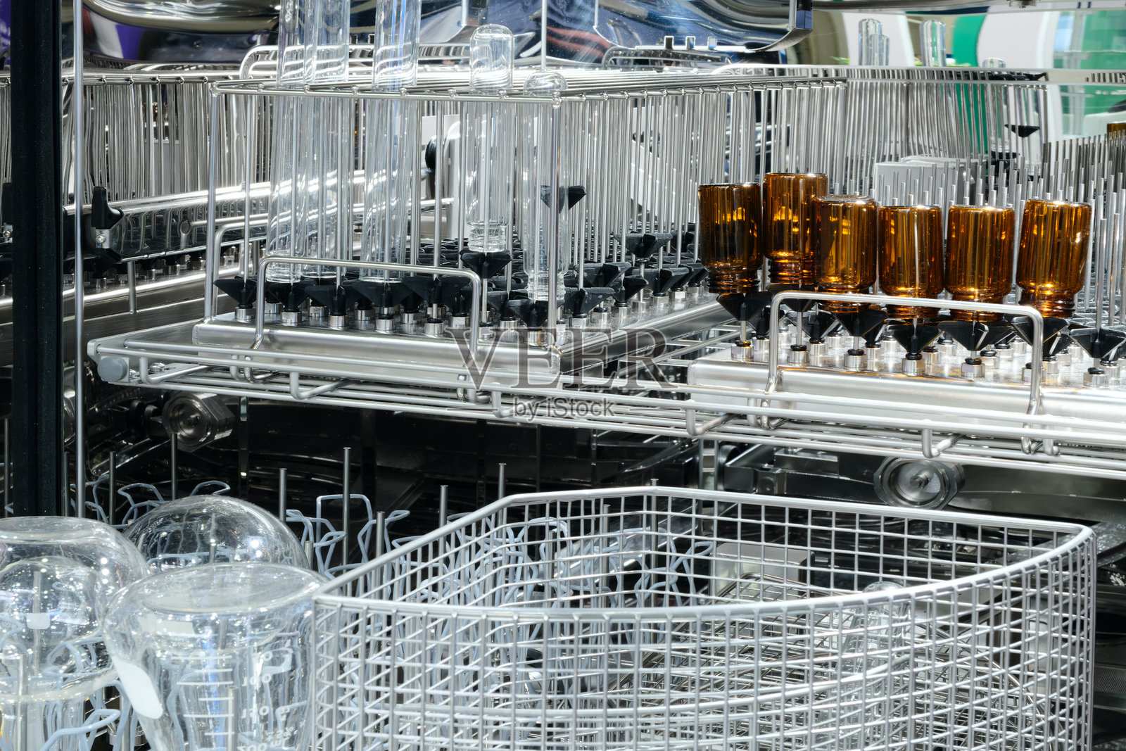 洗碗机正在清洗一架玻璃器皿。玻璃器皿包括各种瓶子和杯子,其中一些上面有数字。照片摄影图片
