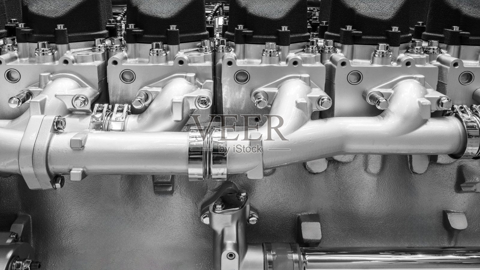一个拥有许多零件的大型发动机。发动机由金属制成,有许多管道和阀门,象征着工业化和机器的复杂性。照片摄影图片