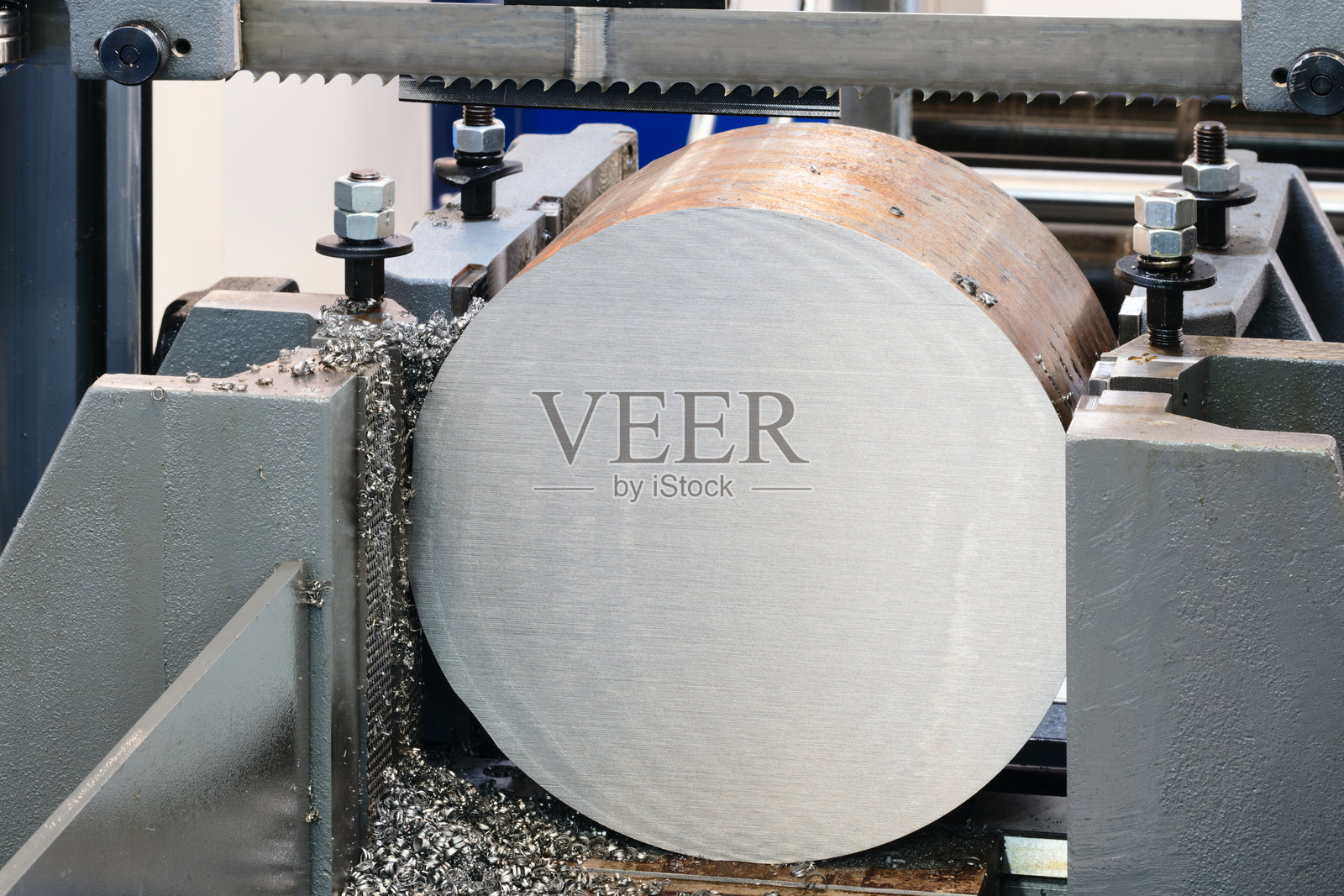 一台机器正在切割一个金属物体,机器是黑色和银色的,被切割的物体是圆形的,工业金属加工概念背景照片摄影图片