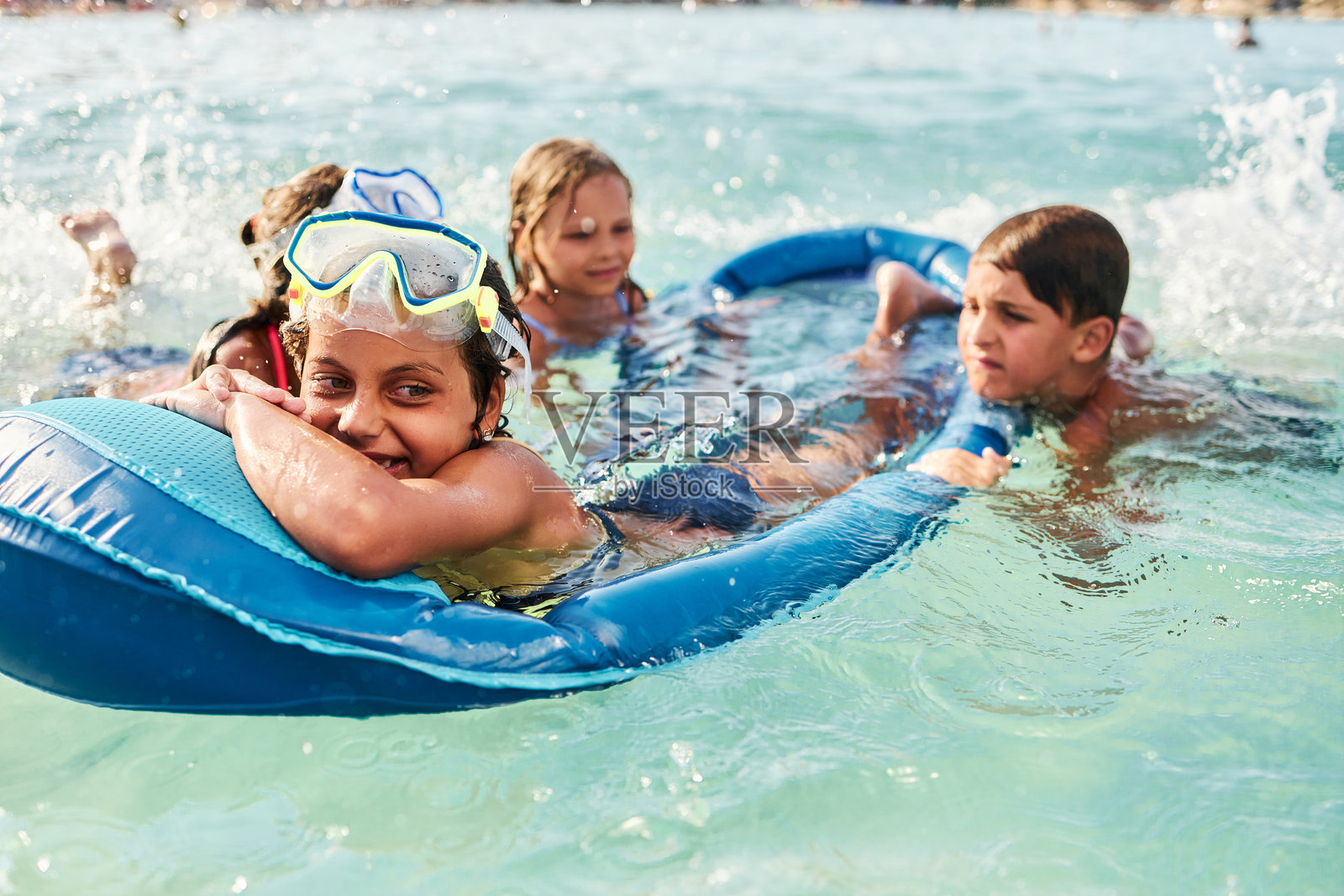 孩子们在海里乘坐充气筏玩耍照片摄影图片