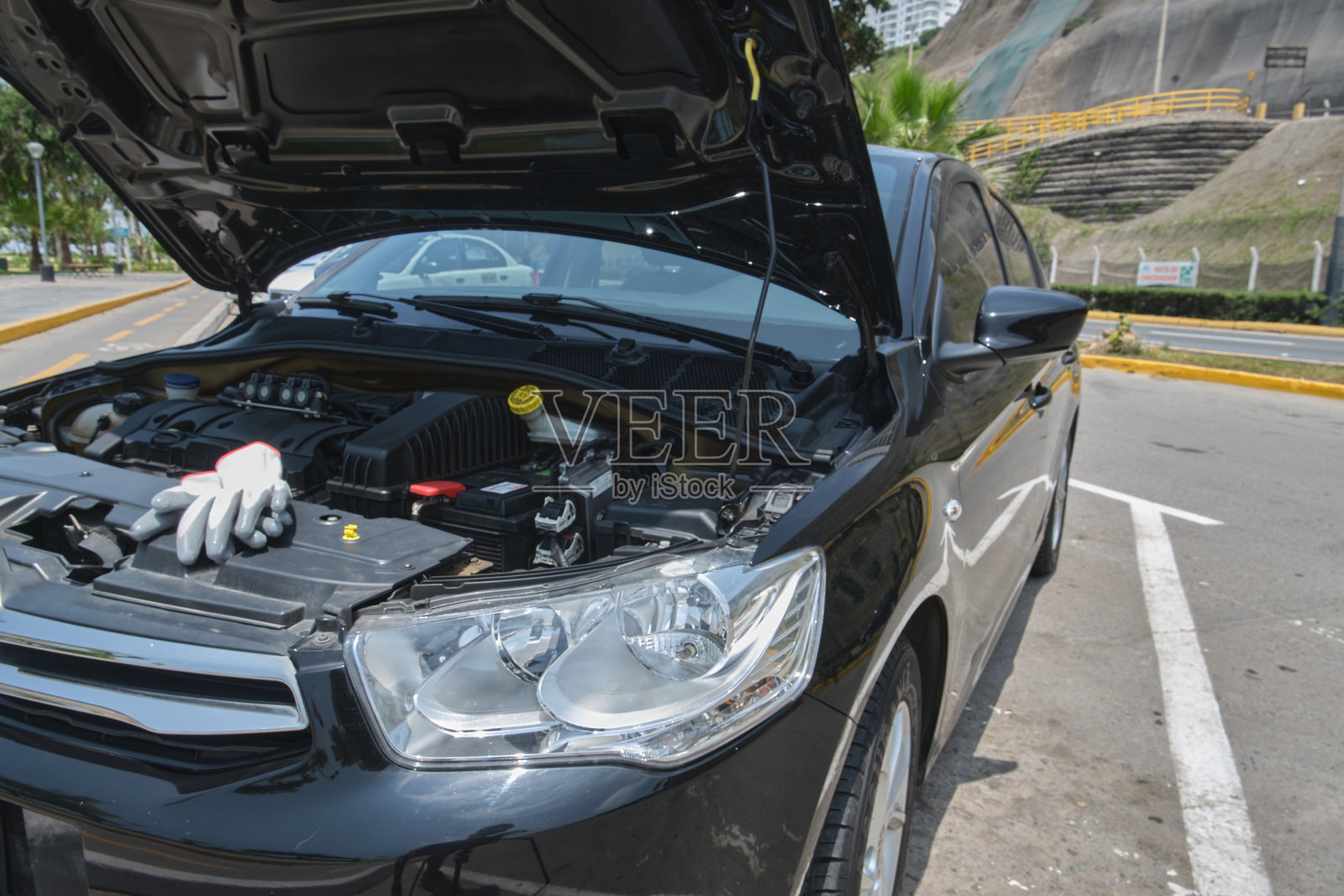 打开引擎盖,戴着手套在发动机上进行维修照片摄影图片