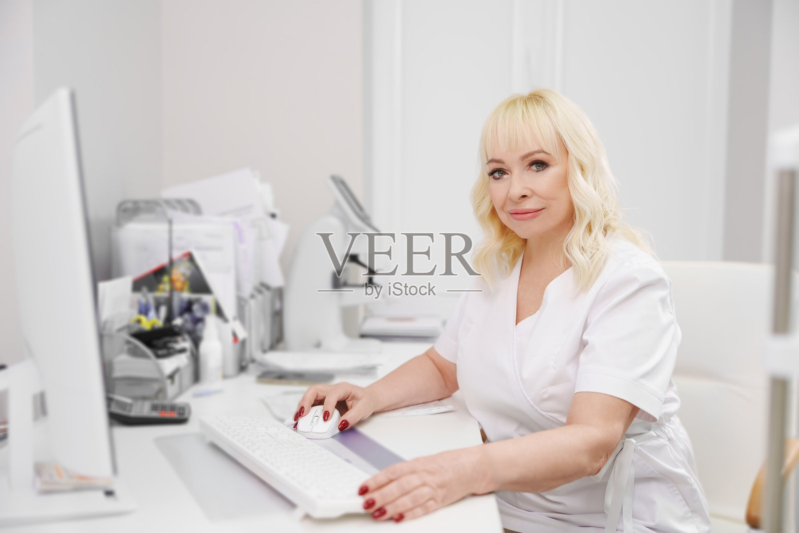 眼科医生在诊所的白色办公桌前工作照片摄影图片