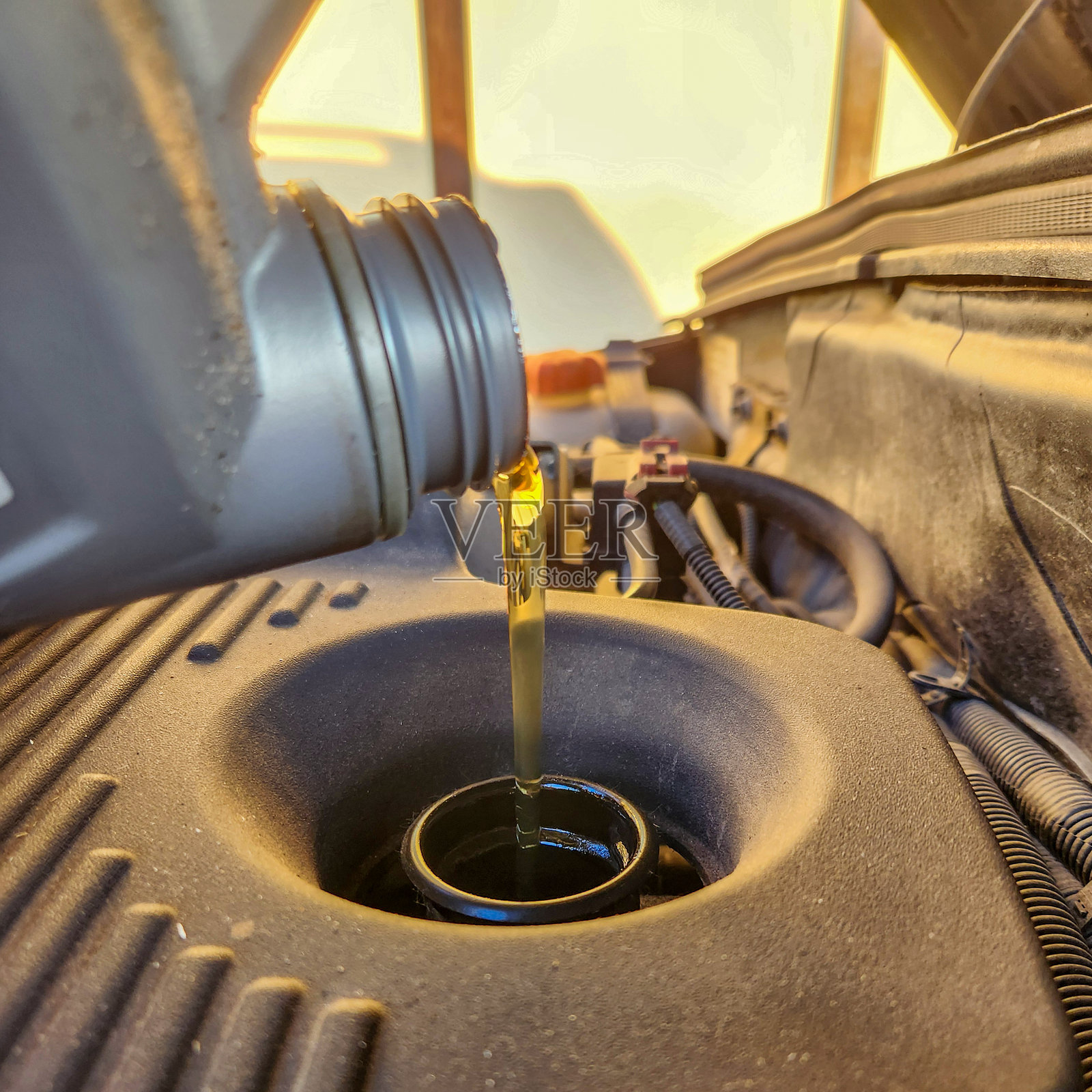 往汽车发动机里倒油照片摄影图片