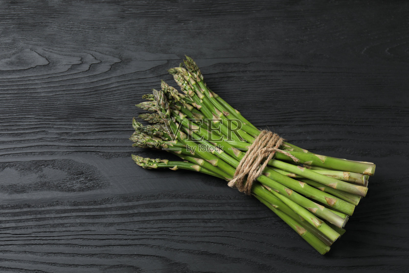 一大把生的绿色芦笋,可食用的芦笋嫩芽,用麻绳捆绑的茎。健康食品,新鲜蔬菜,烹饪食材。照片摄影图片