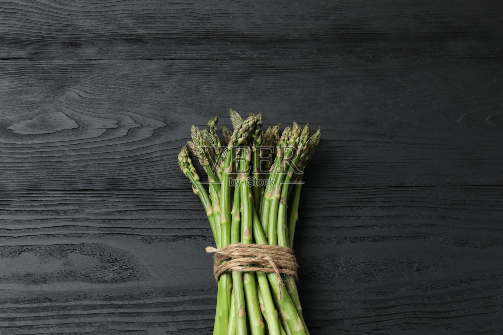 一大捆生的绿芦笋,可食用的芦笋嫩芽,用麻绳捆绑的茎。健康食品,新鲜蔬菜,烹饪食材。照片摄影图片