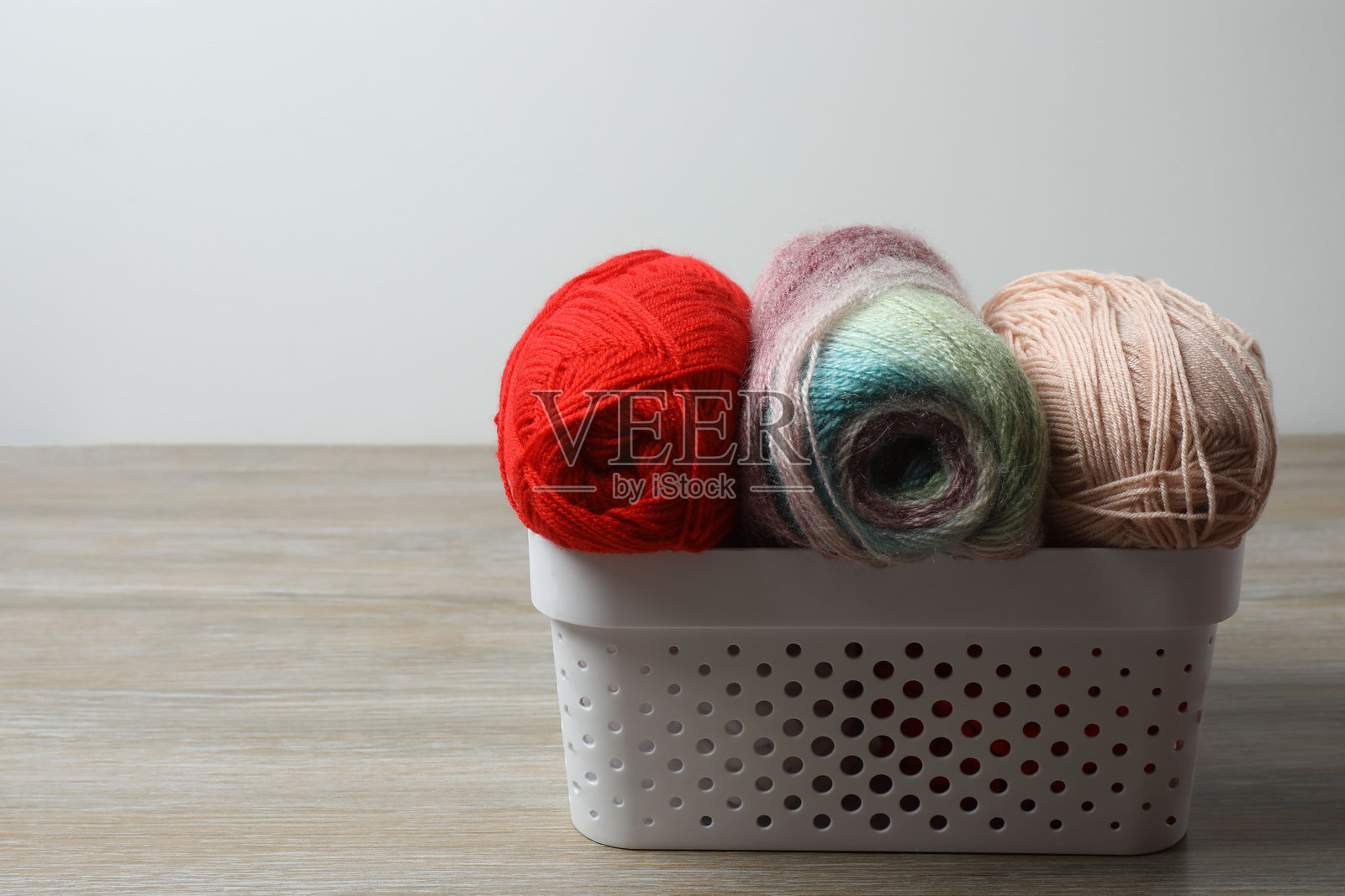 各种毛线和编织针放在木桌上,特写照片摄影图片