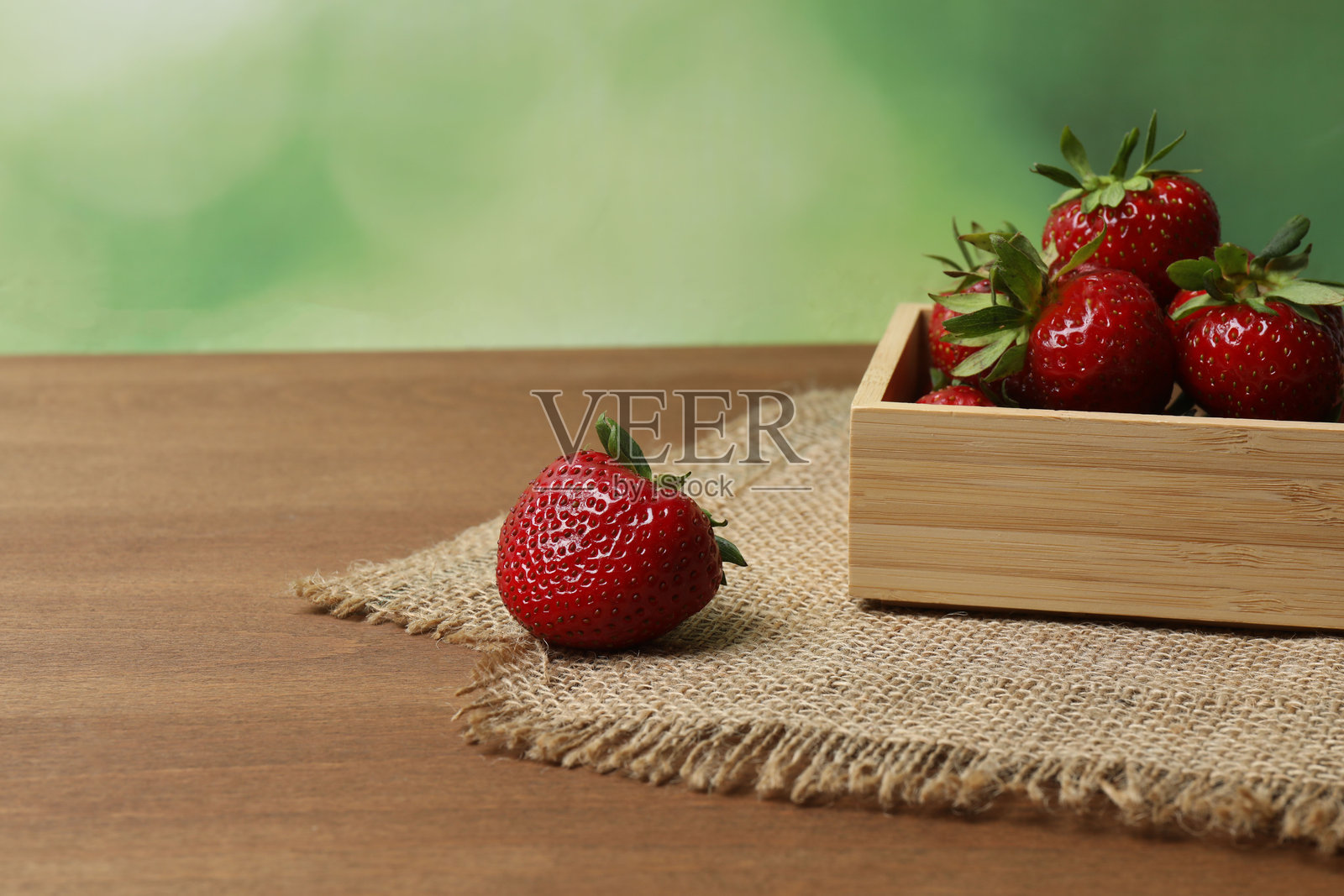 木桌上的托盘里的草莓照片摄影图片