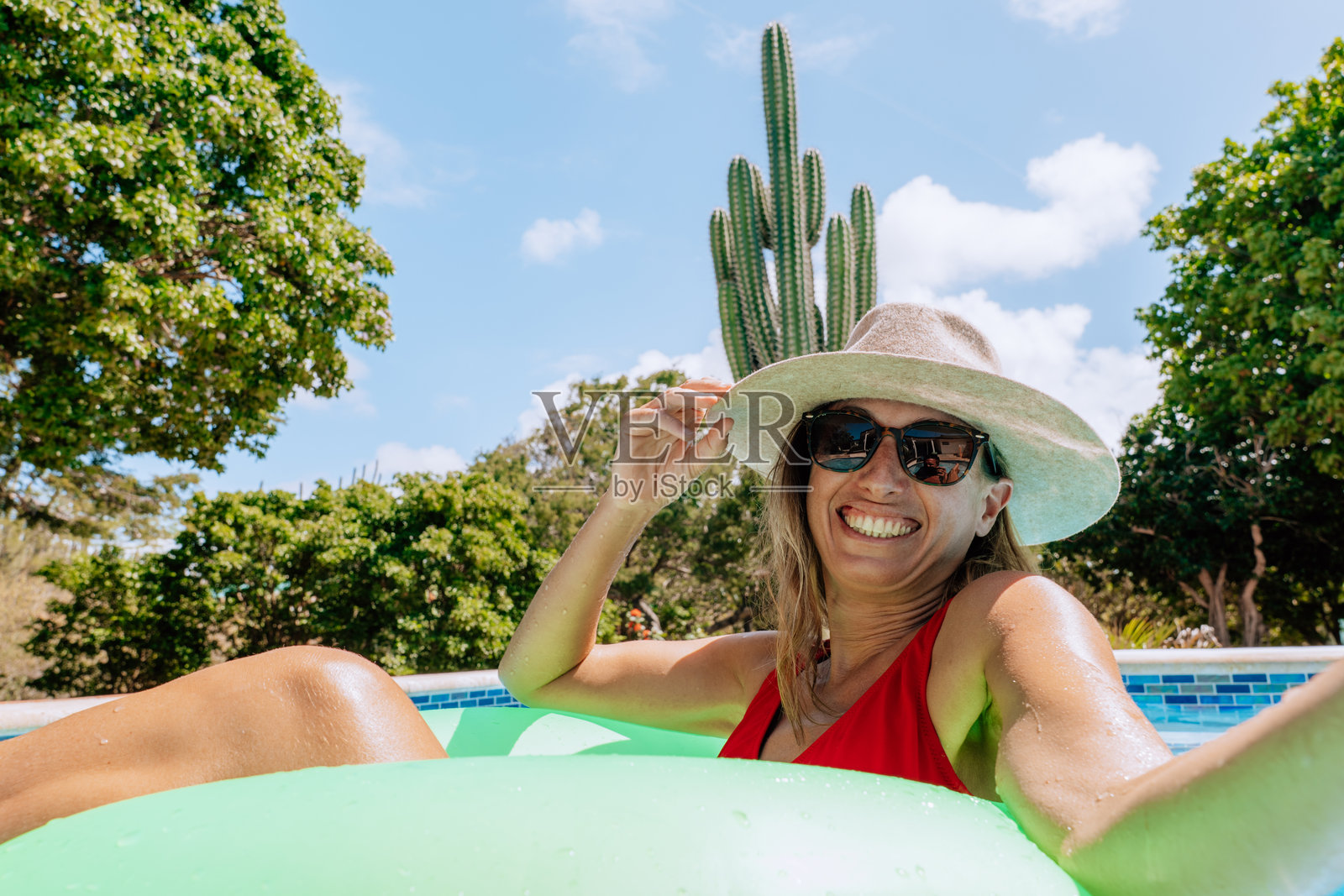 女子坐在绿色泳圈上自拍,享受放松时光照片摄影图片