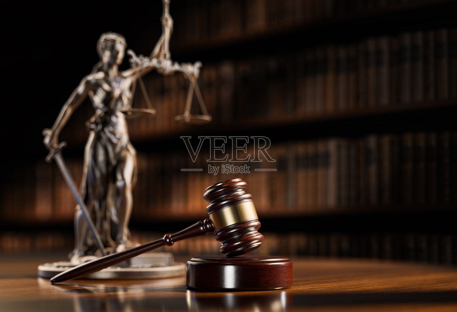 法律概念:正义女神忒弥斯和象征法律与秩序的法官的槌子,背景为书籍照片摄影图片