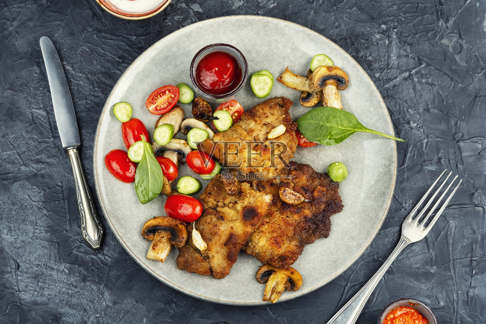 美味的裹面包屑的肉排配烤蘑菇。照片摄影图片