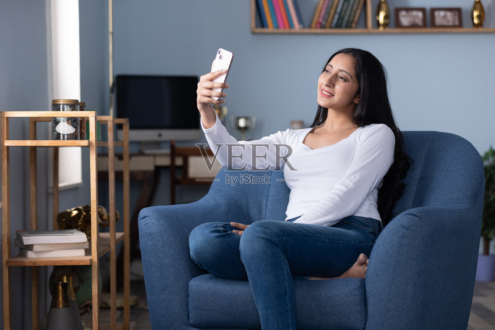 年轻女子坐在沙发上在家使用手机的素材照片照片摄影图片