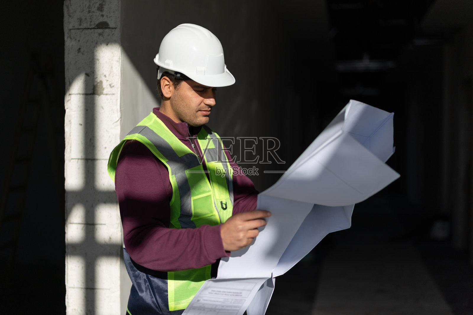 建筑工人在建筑工地审阅蓝图照片摄影图片