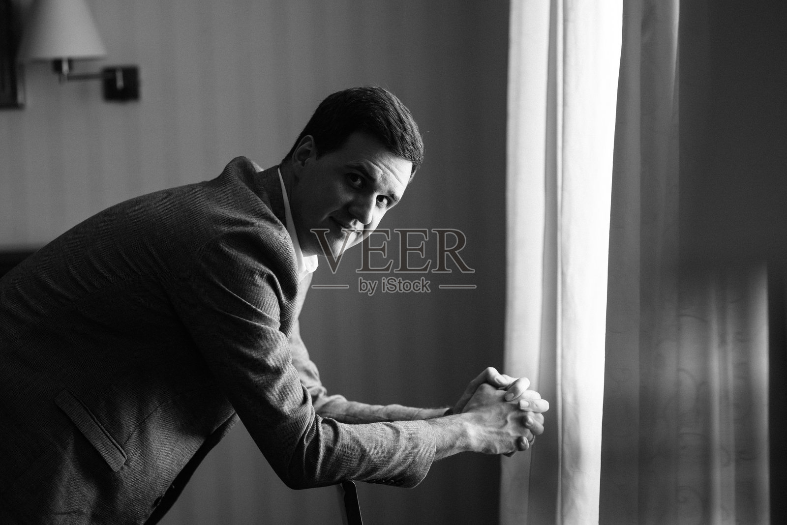 明亮工作室里,身穿蓝色夹克和白色衬衫的年轻新郎肖像照片摄影图片