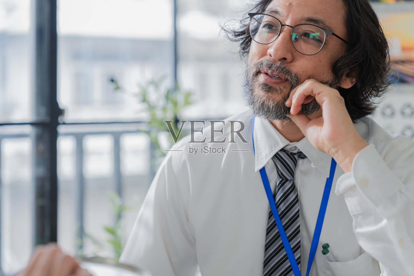 专业的亚洲商务团队在明亮现代的办公室讨论可持续的环保包装解决方案,代表着企业领导力、创新和绿色成功照片摄影图片