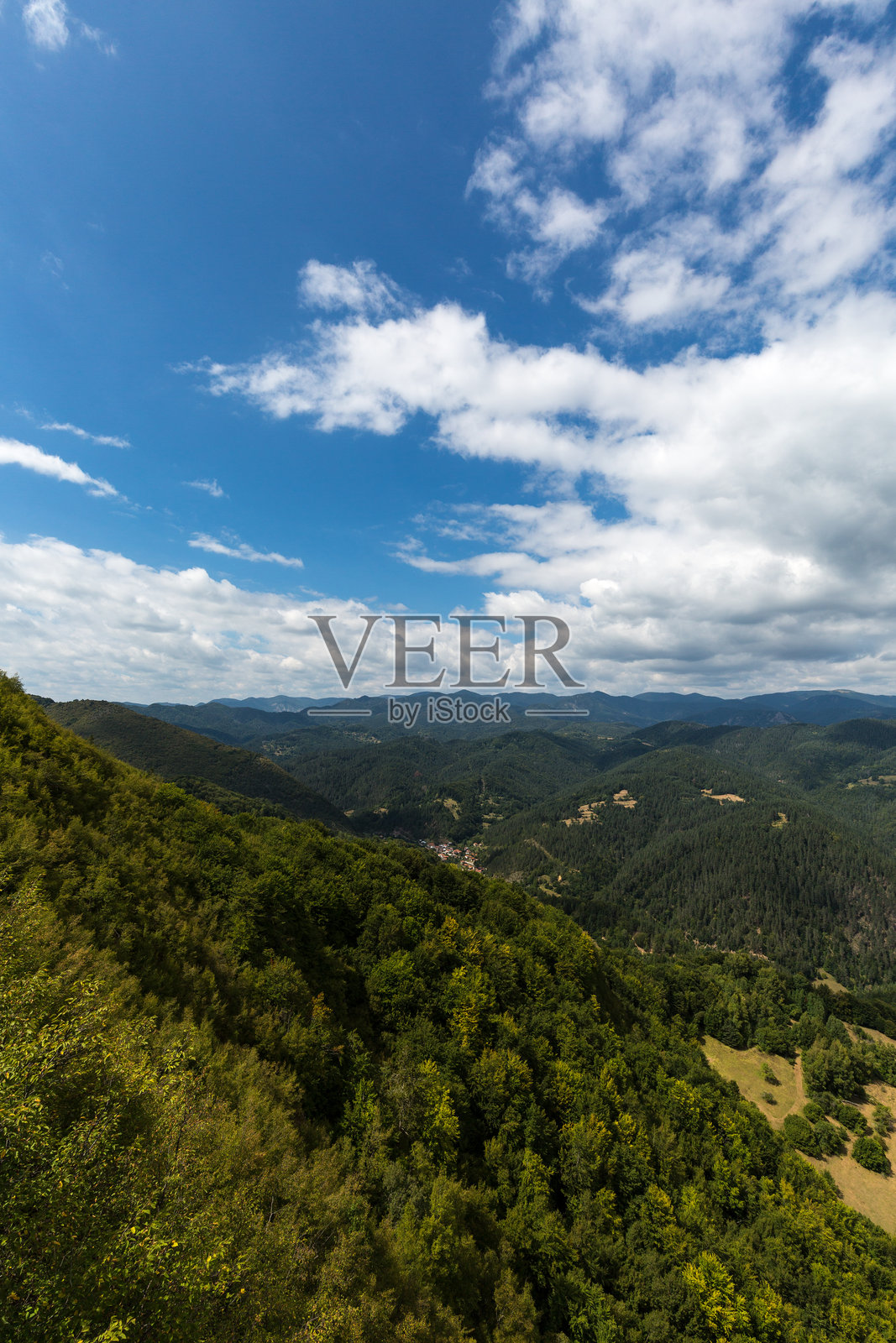 阴云密布的天空下,山峦与森林的景致照片摄影图片