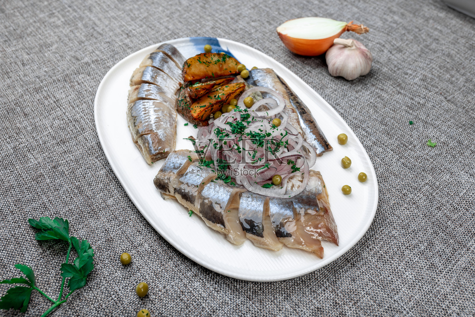 俄式传统冷盘(扎库斯基),包含腌鲱鱼、烤土豆和红洋葱照片摄影图片