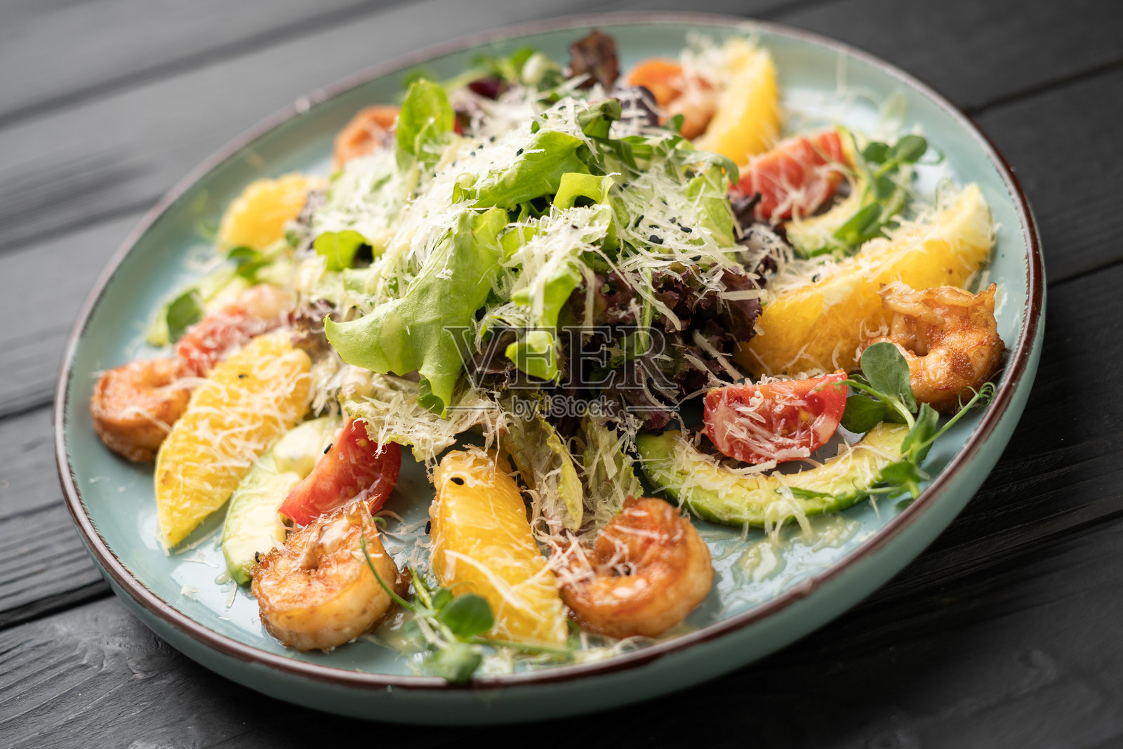 精致餐盘:烤虾、新鲜蔬菜、橙子和牛油果照片摄影图片