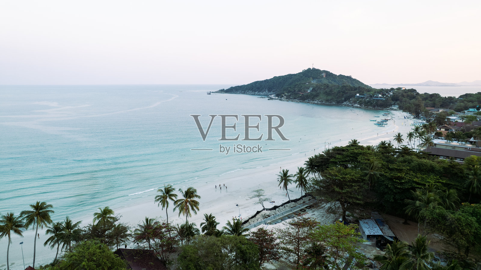 宁静的水面和茂密绿植环绕下的迷人热带海滩照片摄影图片