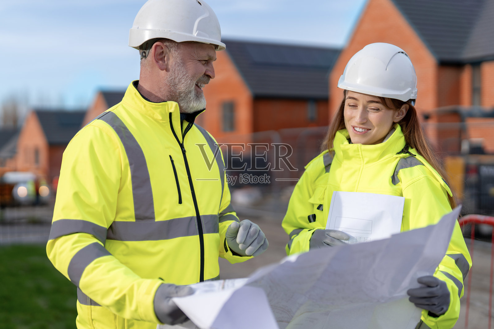 建筑团队在住宅开发区审阅新住房项目蓝图照片摄影图片