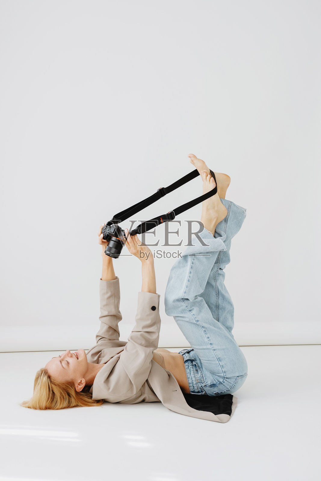 一位美丽的女性摄影师,手持数码相机,以极简风格进行拍摄。照片摄影图片