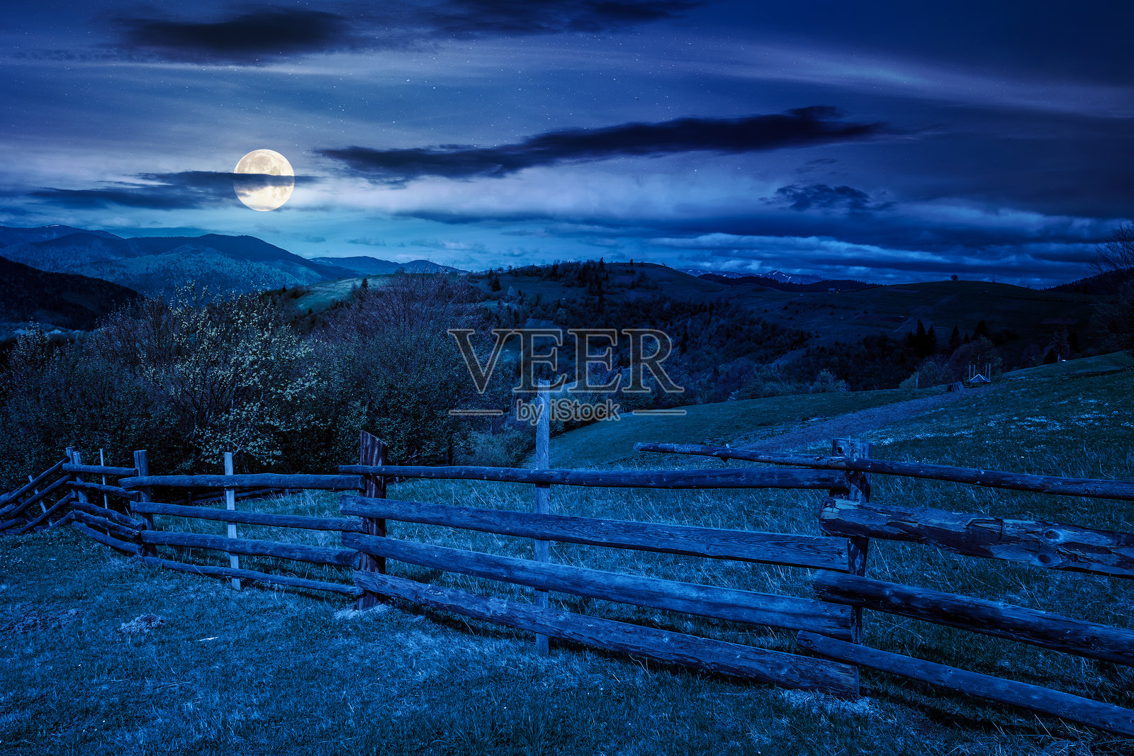 夜晚的绿色乡村景观,带有木栅栏照片摄影图片