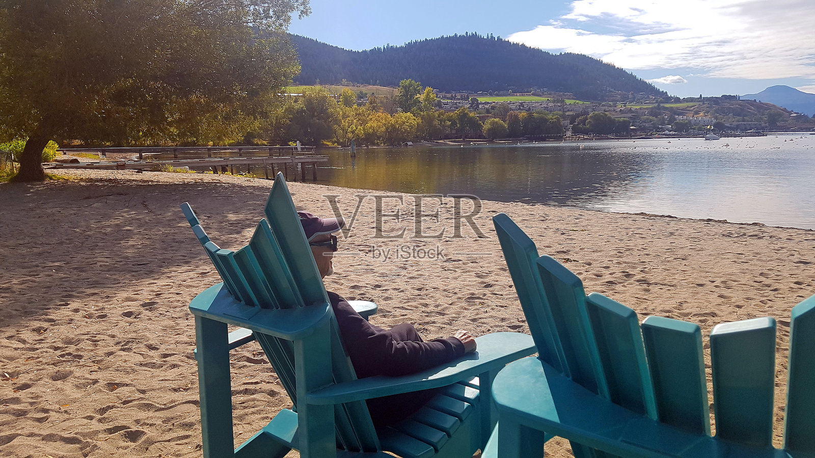 一位年长的男士正在欣赏奥肯那根湖和海滩的秋日景色照片摄影图片