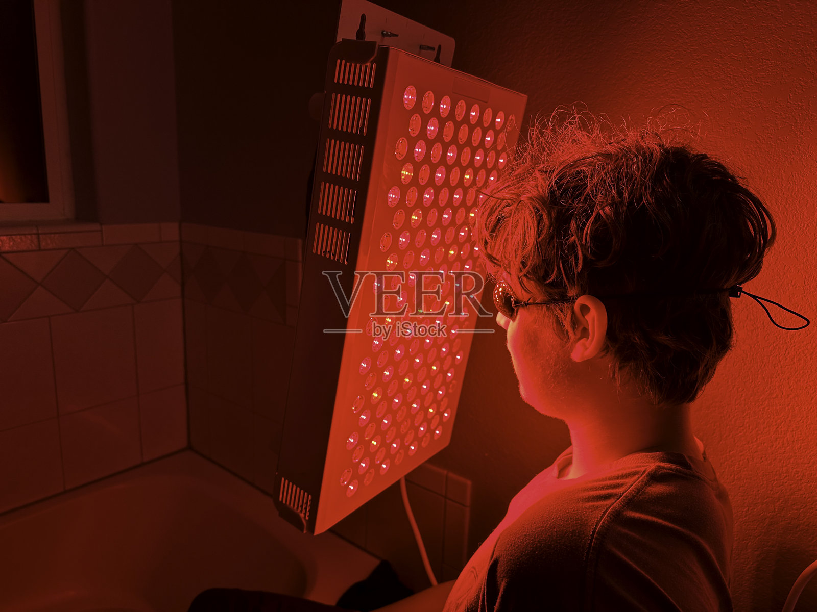 青少年使用红光治疗痤疮照片摄影图片