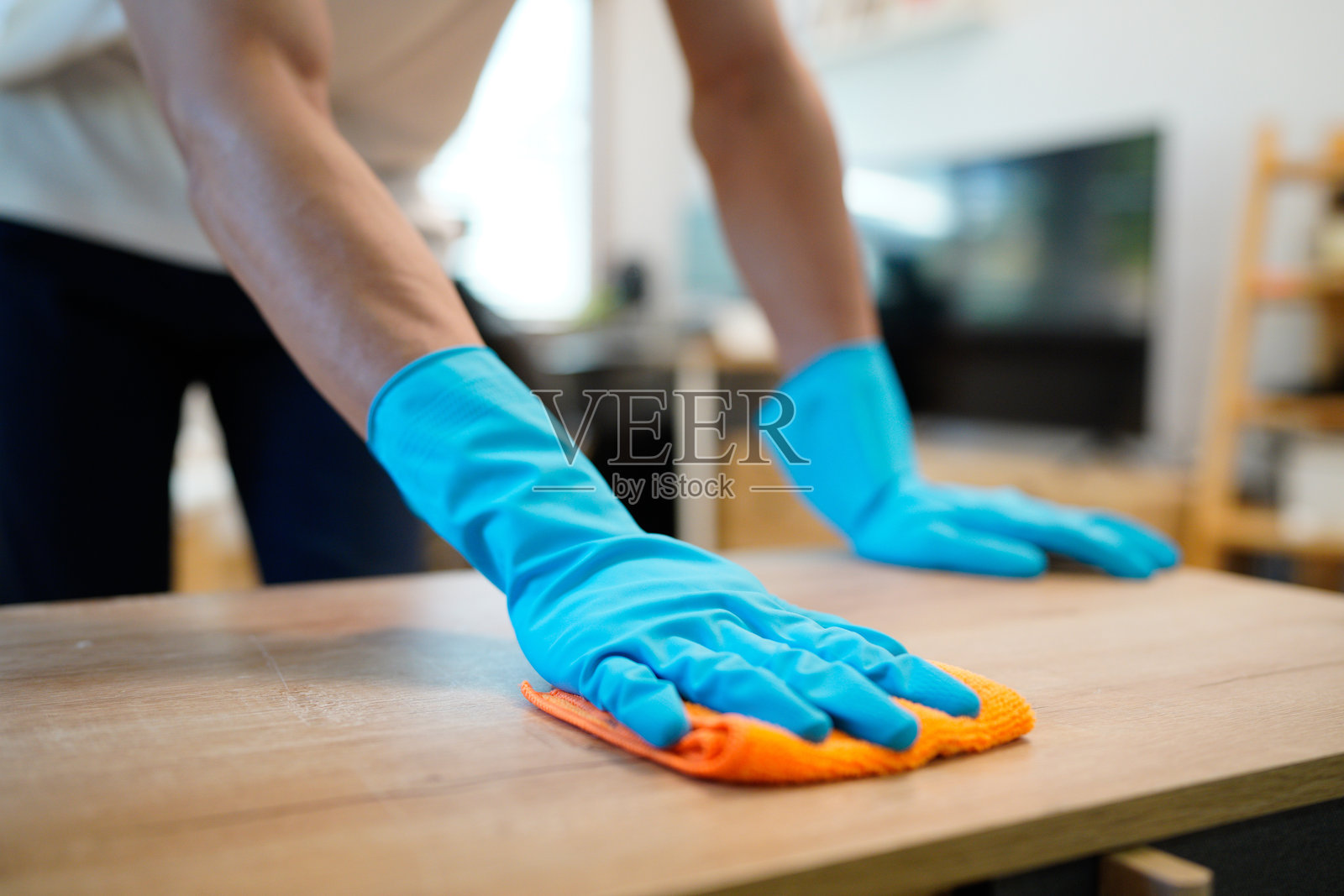 男人正在用抹布仔细擦拭抽屉,做家务,保持客厅整洁干净照片摄影图片