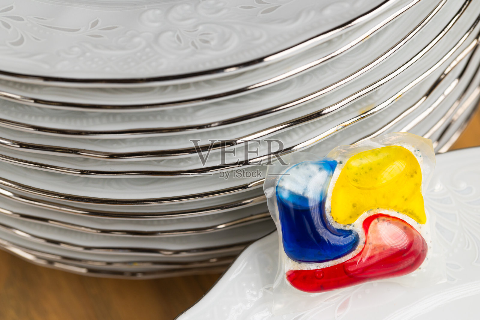 洗碗机洗涤剂胶囊和一叠盘子照片摄影图片