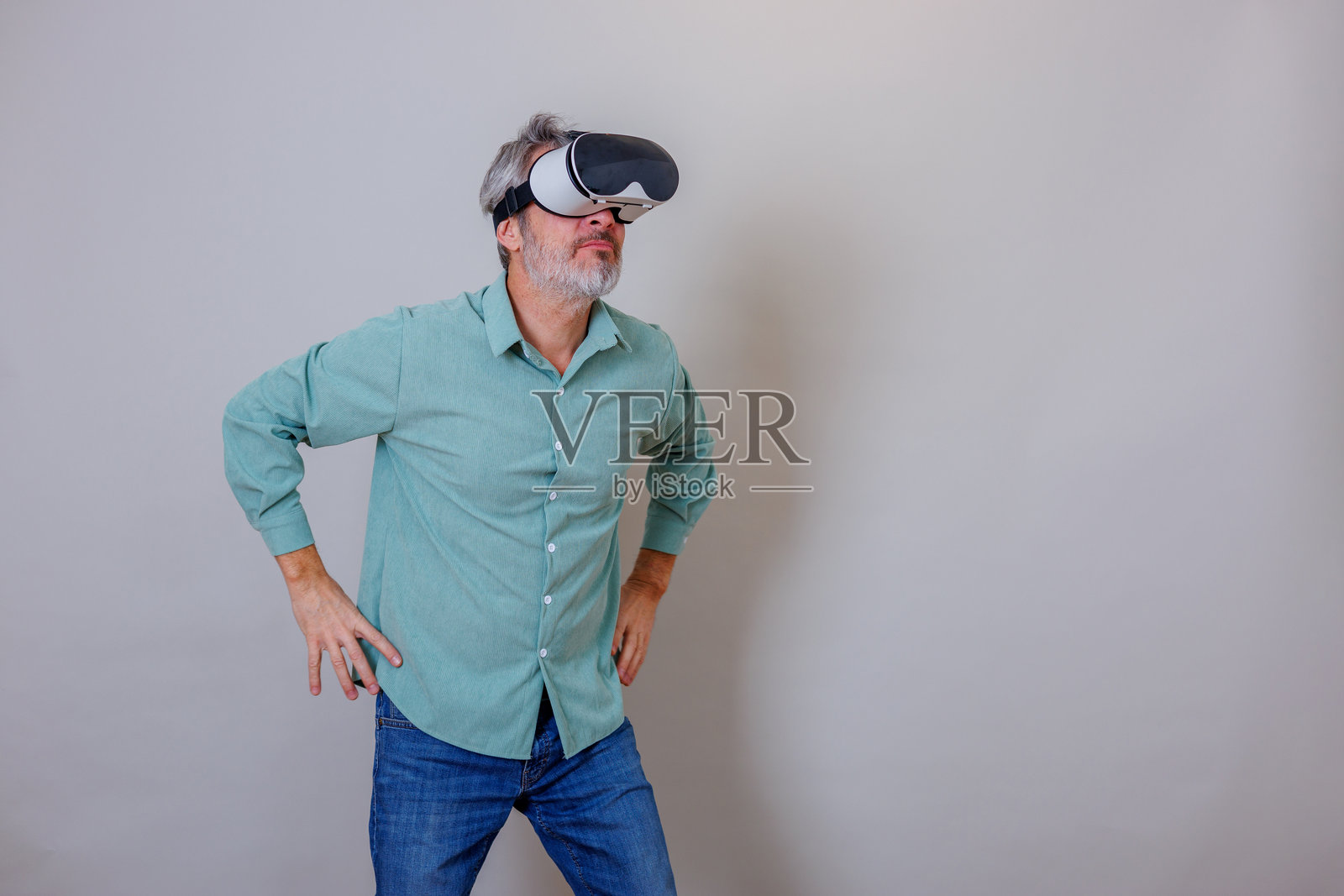 一位成熟的成年男子佩戴虚拟现实头显,探索元宇宙技术和沉浸式数字世界照片摄影图片