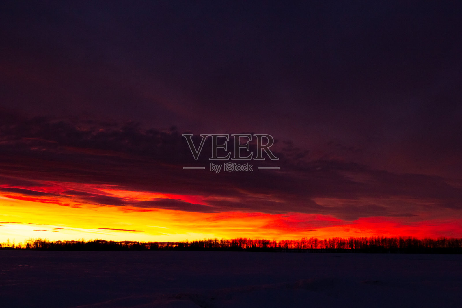 冬季草原上色彩鲜艳的红橙色日落天空。照片摄影图片