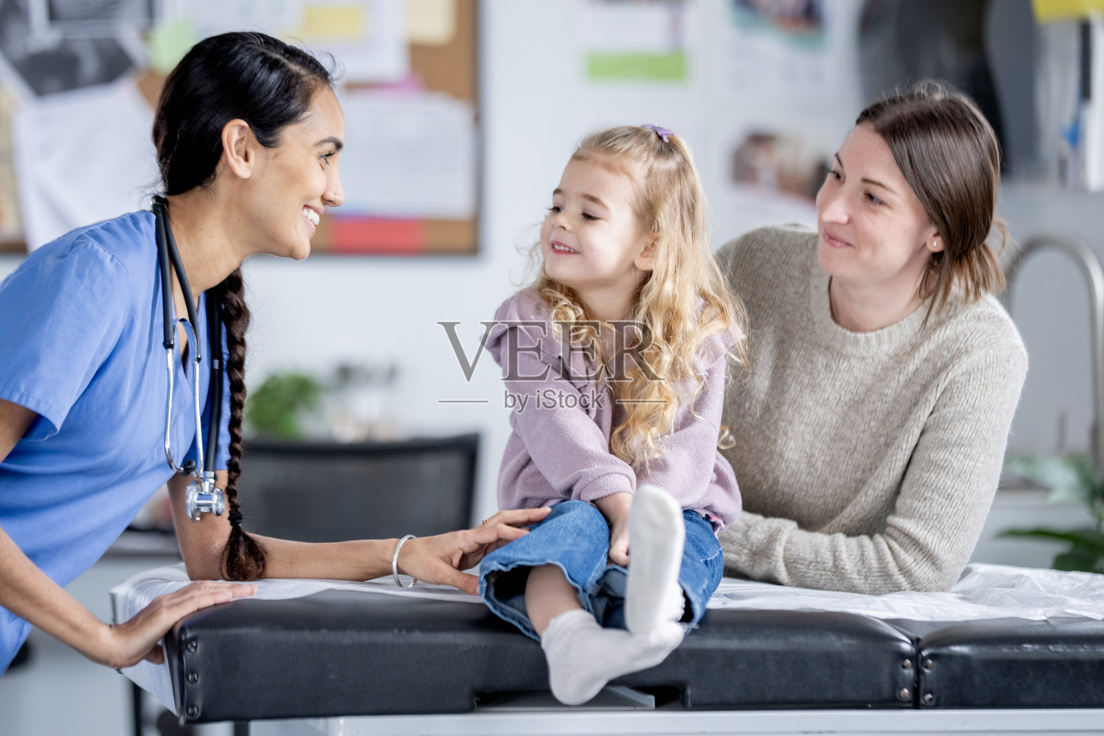 南亚护士在温馨的家庭医生就诊期间为儿科患者提供建议照片摄影图片
