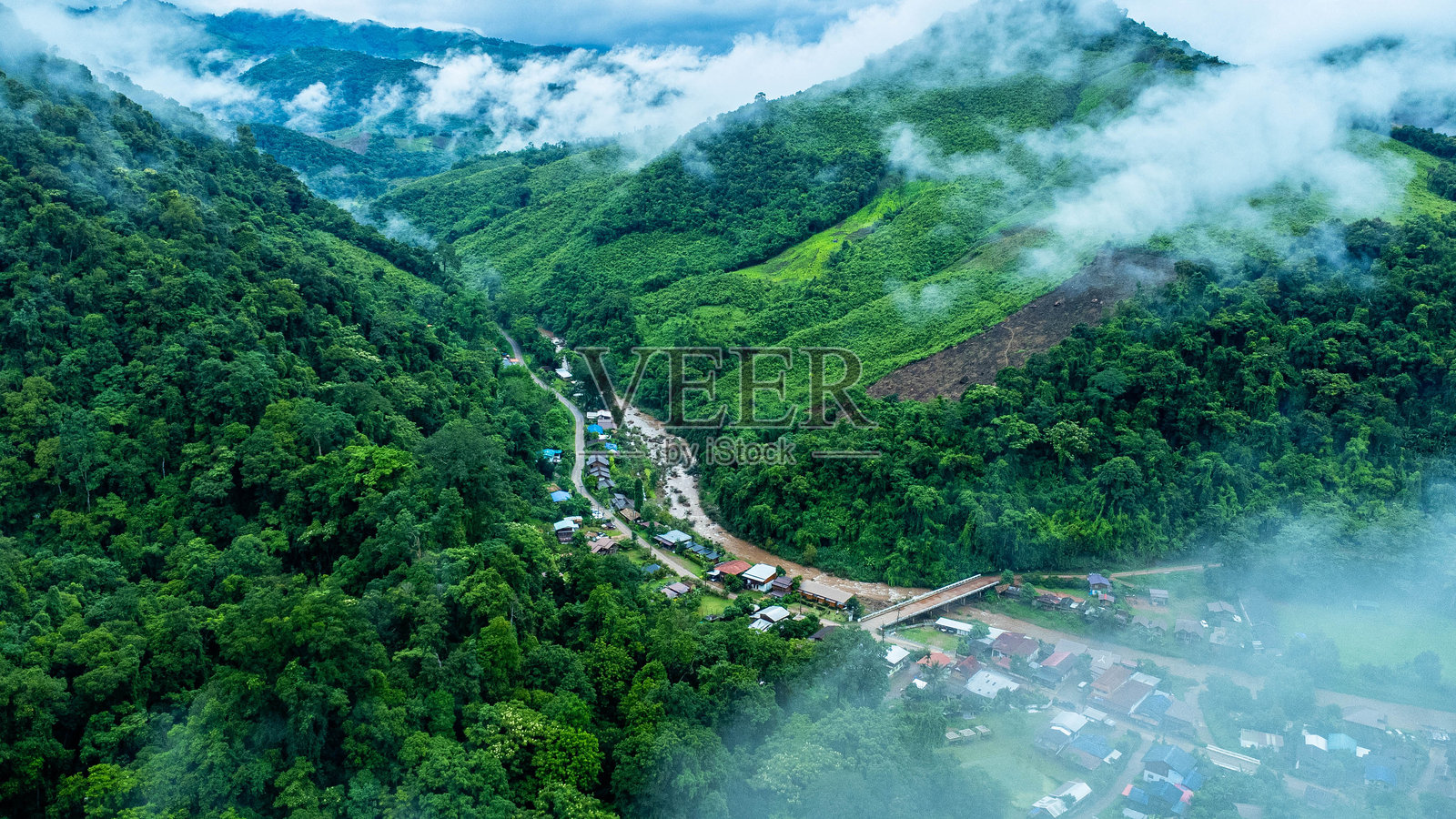 泰国楠府雨季期间山谷中沙潘村庄和绿色稻田的鸟瞰图照片摄影图片