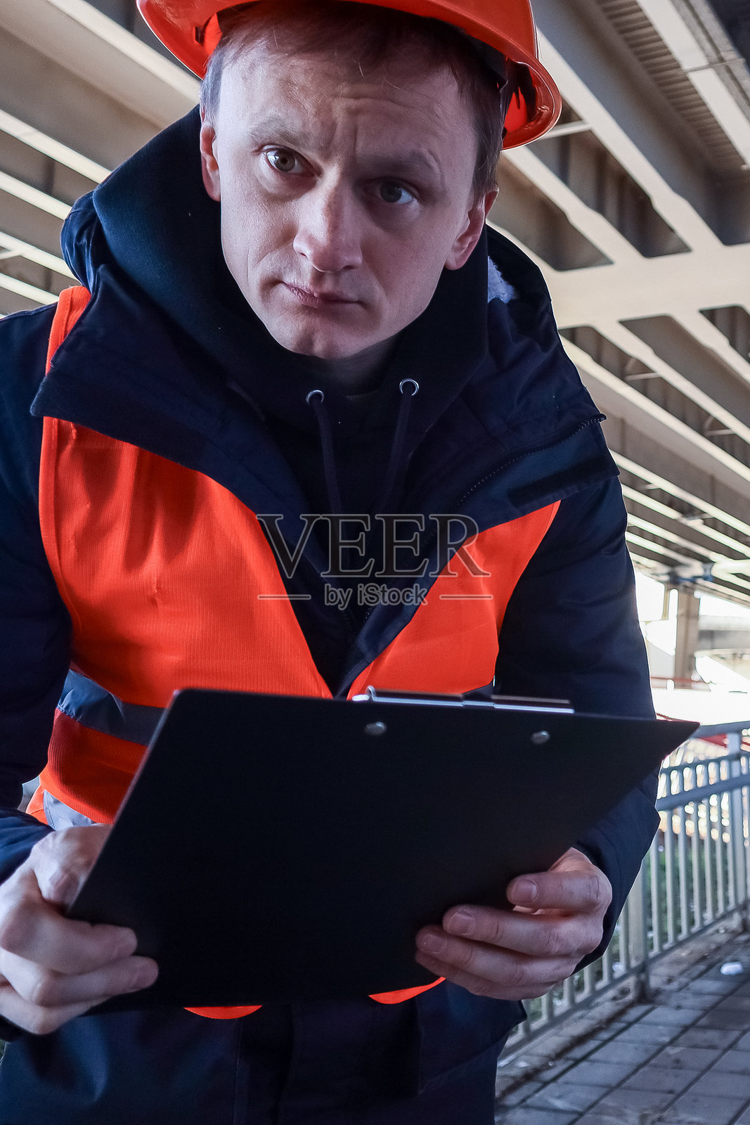 工程师在立交桥下,使用剪贴板进行特写拍摄照片摄影图片