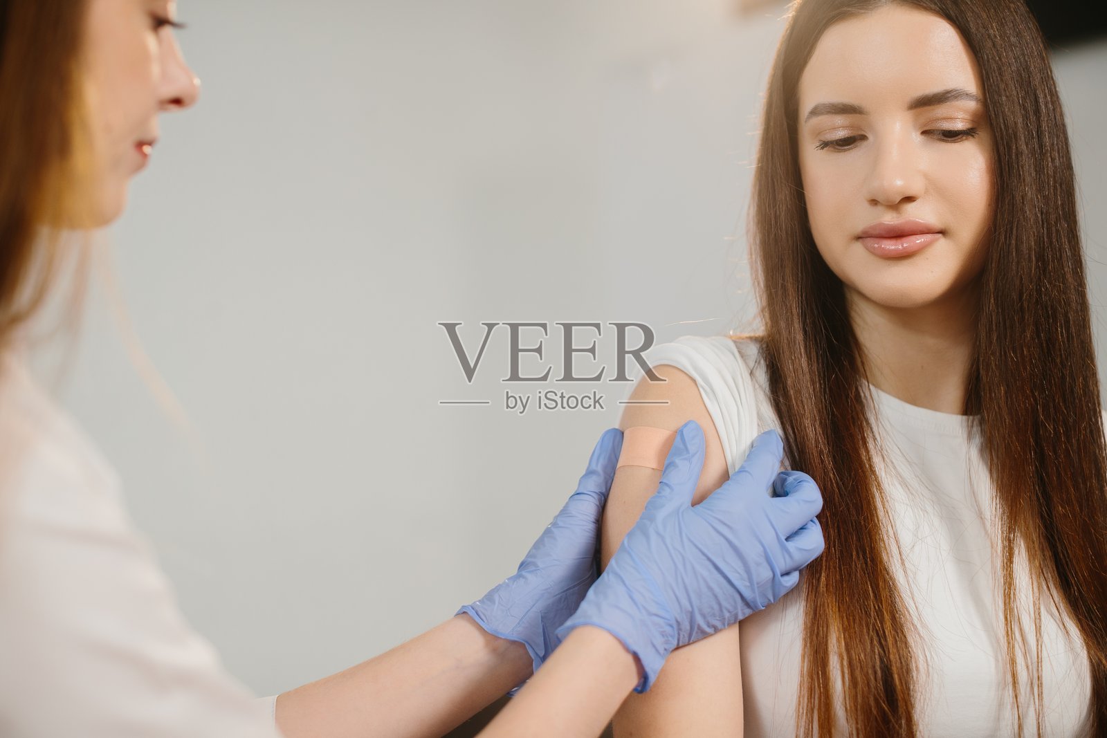 医护人员在患者接种疫苗后为其包扎照片摄影图片