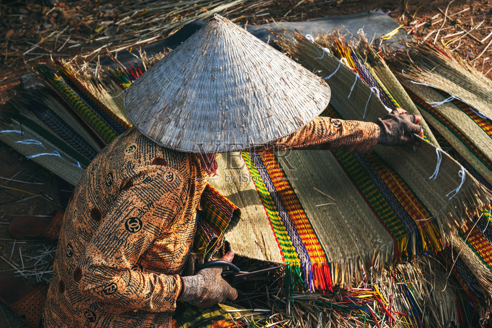 越南妇女在越南手工艺村的草席厂戴着传统草帽“农拉”工作照片摄影图片