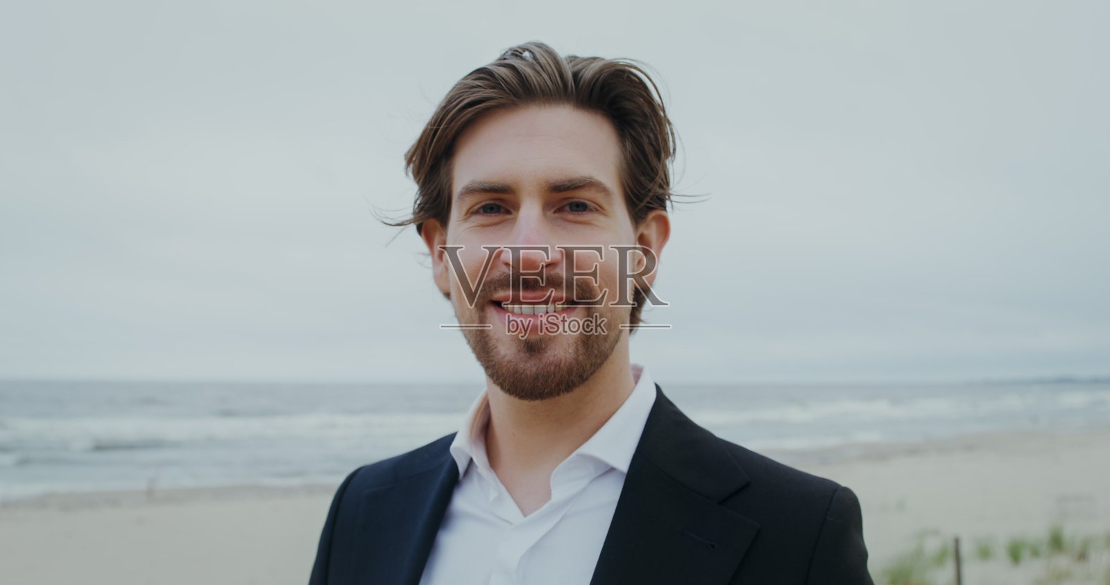 身着正装的男子微笑着看向婚礼照片摄影图片