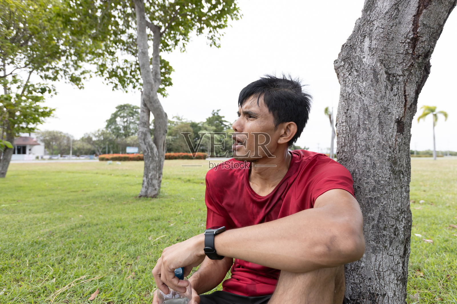 亚洲男性运动员在户外公园运动后休息照片摄影图片