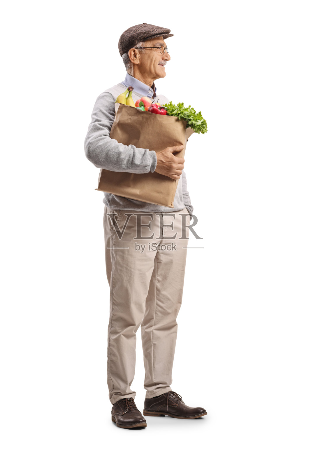 一位老年男子提着杂货站着照片摄影图片