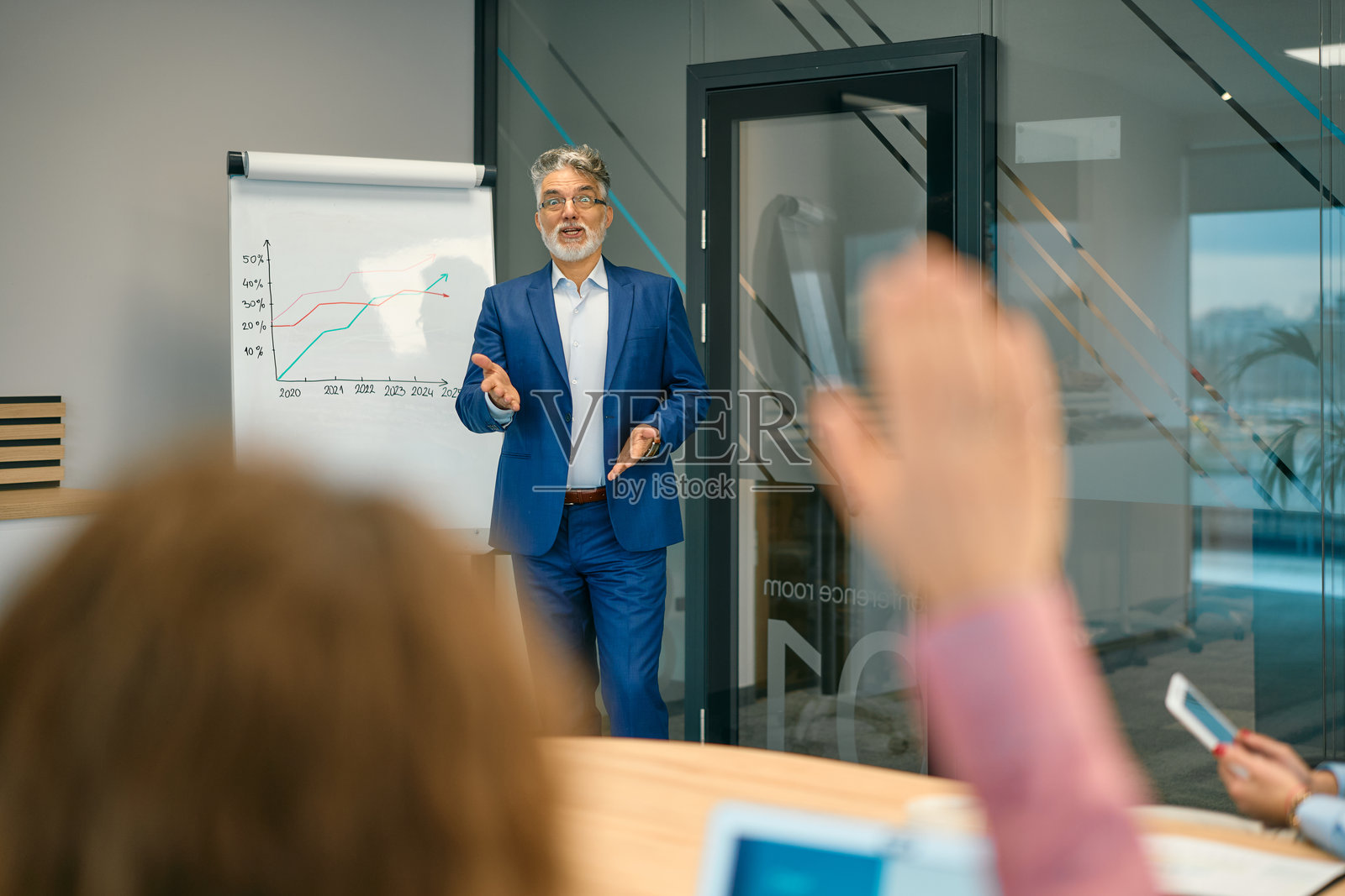 一位资深商业领袖在办公室向同事们做演示照片摄影图片