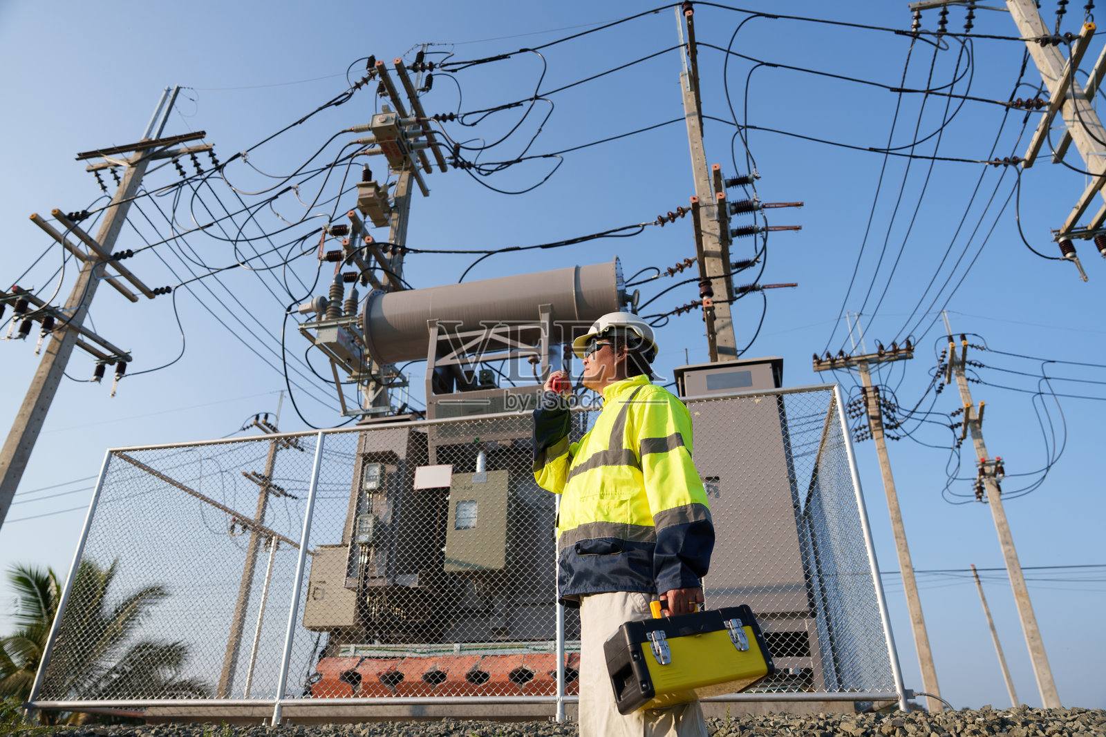 一位专业工程师在偏远农村地区检查高压变压器。(照片)照片摄影图片