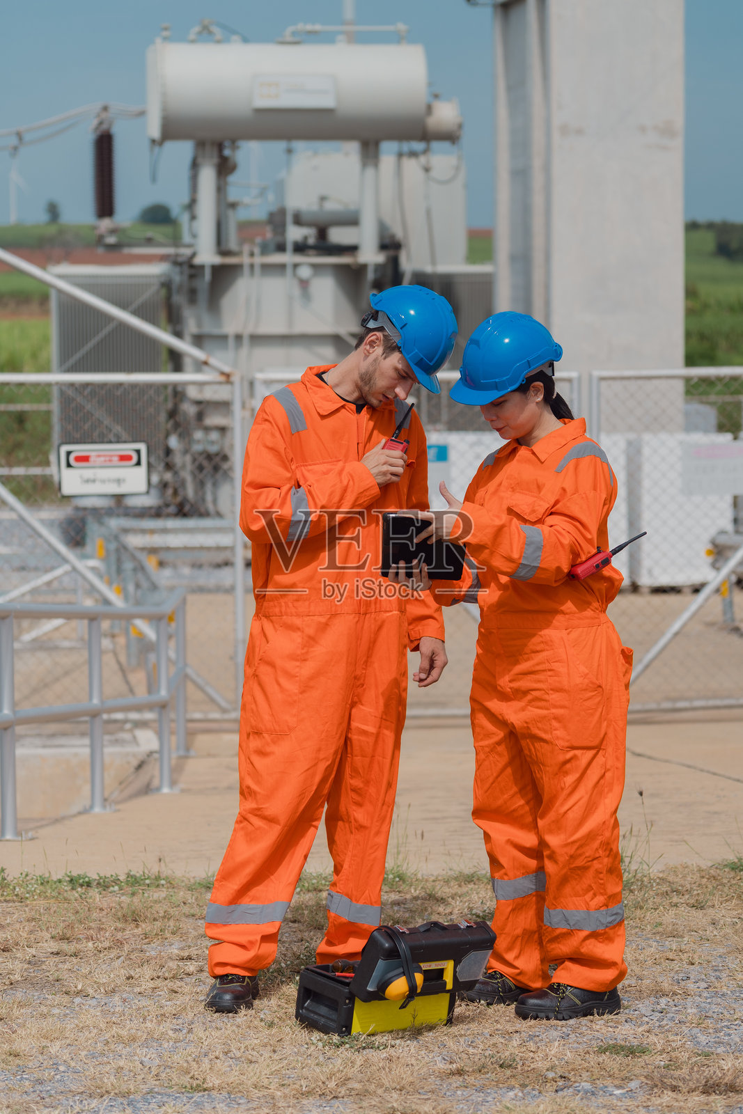 电气工程师正在检查从风力发电场接收电力的变电站内的运行和配电系统。照片摄影图片